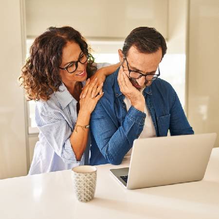 Couple using laptop to check their State  Pension