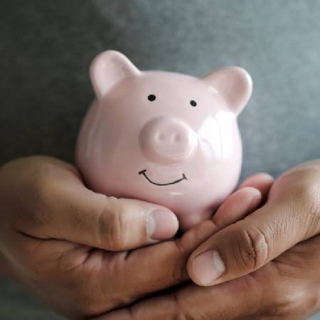 Hands holding piggy bank | State Pension triple lock