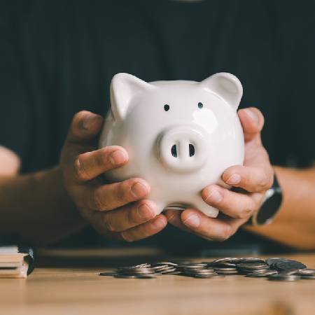 Man holding piggy bank | How to avoid a pension scam