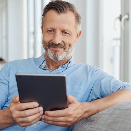 Man holding tablet looking into early retirement pension options