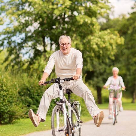 Mature couple riding bikes along a path