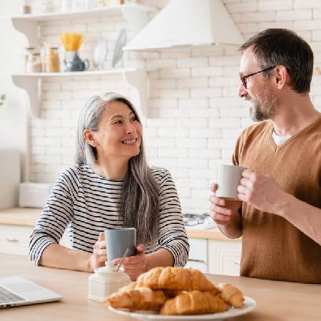 Middle aged couple having a coffee in the kitchen | Collective defined contribution pensions