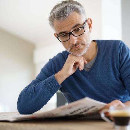 Man sitting down reading the paper 