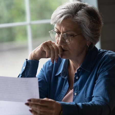 Older lady with glasses reading about the State Pension