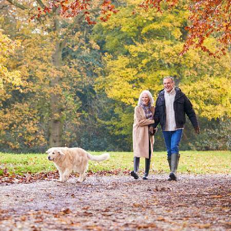 Couple walking their dog | Reduce financial stress in retirement