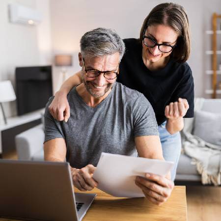 Happy couple checking their pension paperwork | Why you could have more savings than you think