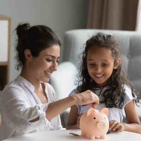 Mother putting coins in child's piggy bank |  Should I start a pension for my child?